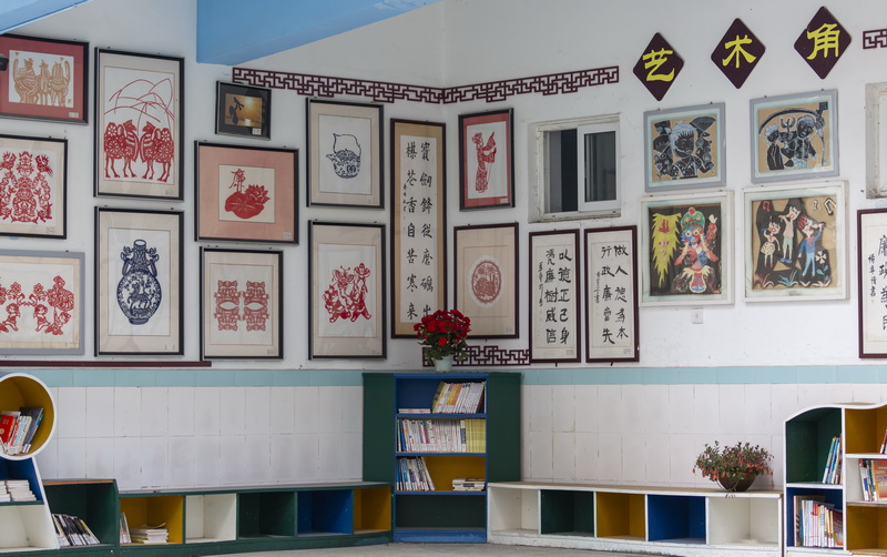 彭州市实验小学让每面墙都说话,这是用师生书画作品布置的图书角.